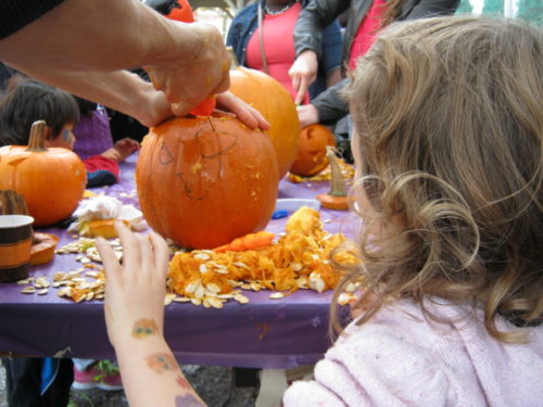 Kids carving free pumpkins at the Junction Toronto's Pumpkinfest sponsored by the Sweet Potato and presented by the Junction BIA